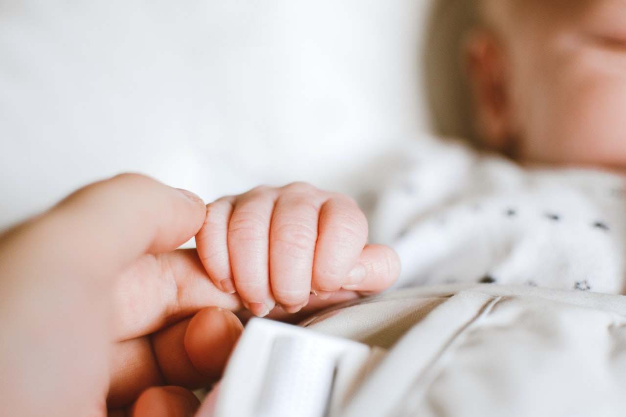 Mãe segurando a mão de recém-nascido. (Foto: Ilustração/Lisa Fotios/Pexels)