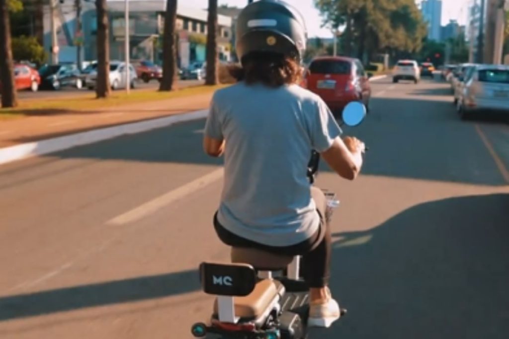 Imagem mostra mulher andando com bike elétrica, em Goiânia.