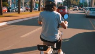 Imagem mostra mulher andando com bike elétrica, em Goiânia.