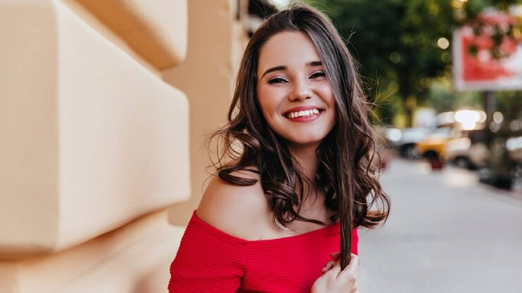 Foto de uma mulher sorrindo e desmontando ser uma pessoa atraente