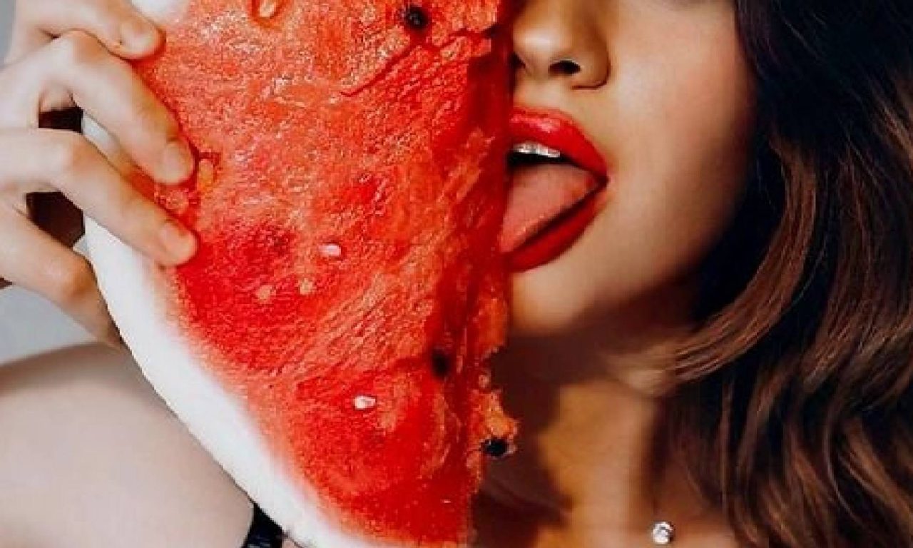 Mulher segurando uma melancia que é um alimento que aumenta o tesão