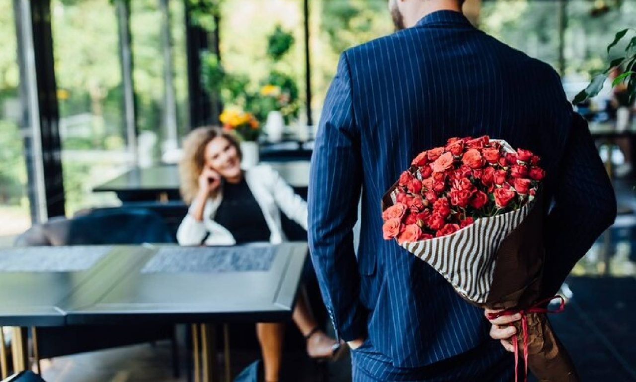 Um rapaz entregando flores para uma mulher, essas atitudes vem de tipos de homem que são raros