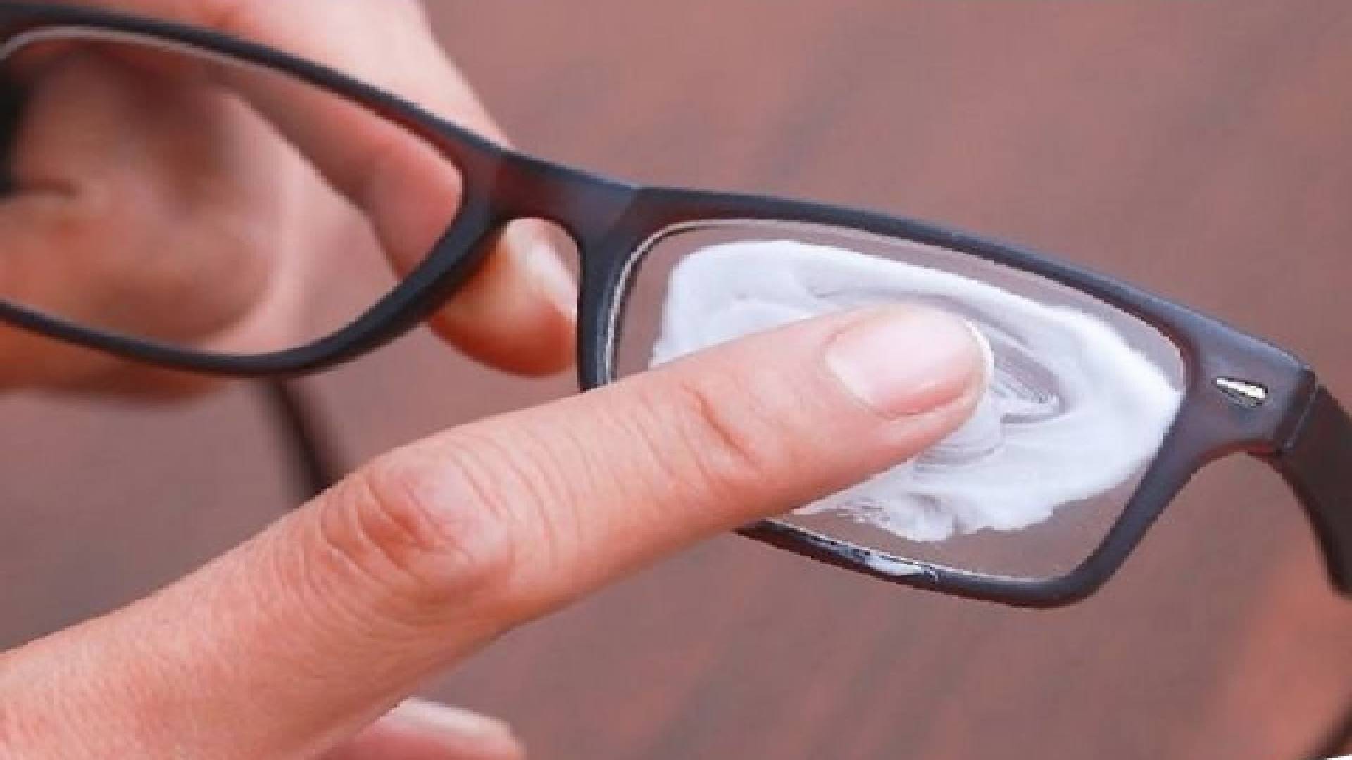 Pessoa passando pasta de dente para tirar os arranhões dos óculos