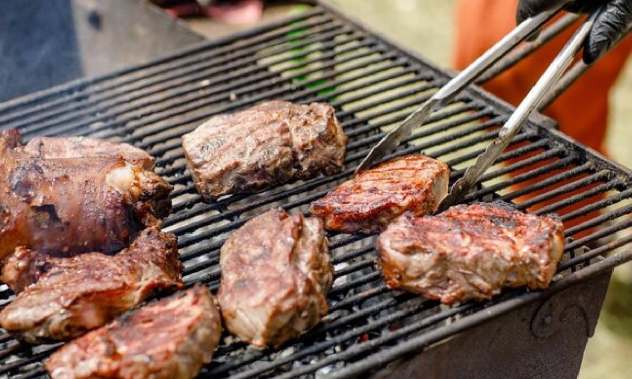 Pessoa assando melhores carnes para fazer na grelha