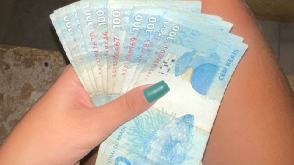 signos Pessoa segurando dinheiro simbolizando signos de podem ficar ricos