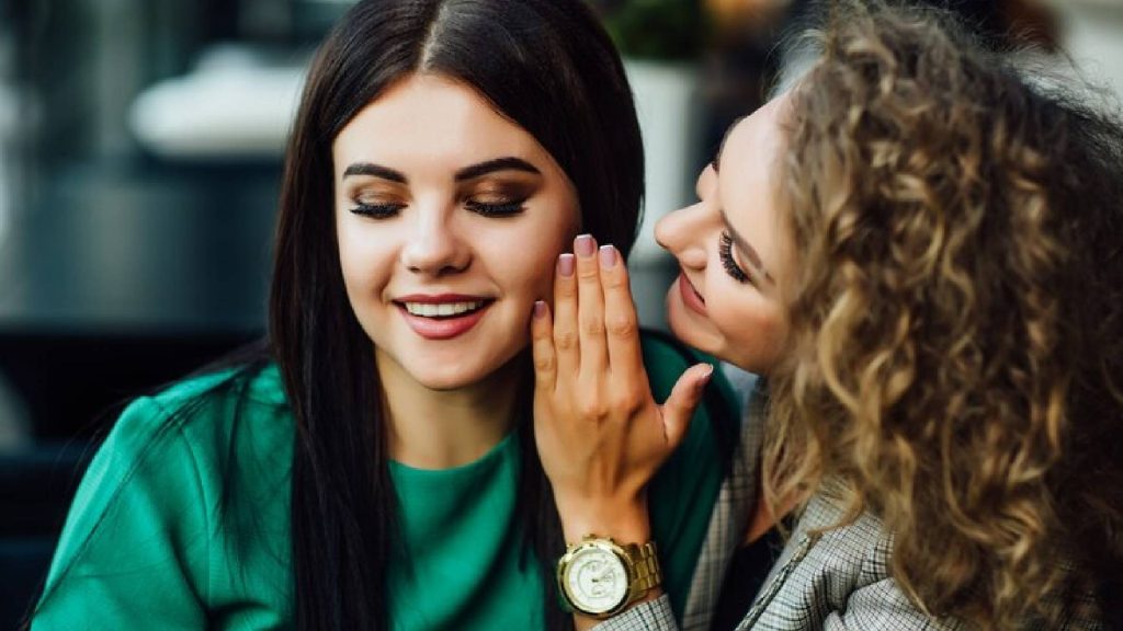 Mulher contando fofocas um sinal de que a pessoa pode ser mentiroso compulsivo