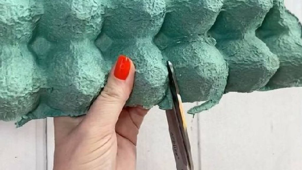 Mulher recortando caixa de ovo