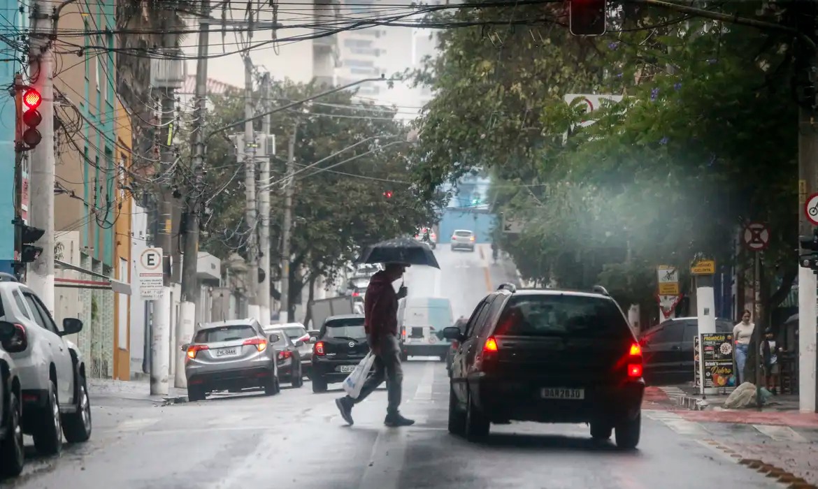 Pessoa andando na rua com guarda-chuva. (Foto: Paulo Pinto/Agência Brasil)