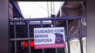 Placa colocada em portão de casa chama atenção de quem passa na rua