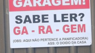 Placa na porta de garagem chama atenção de quem passa pela rua: “sabe ler?”