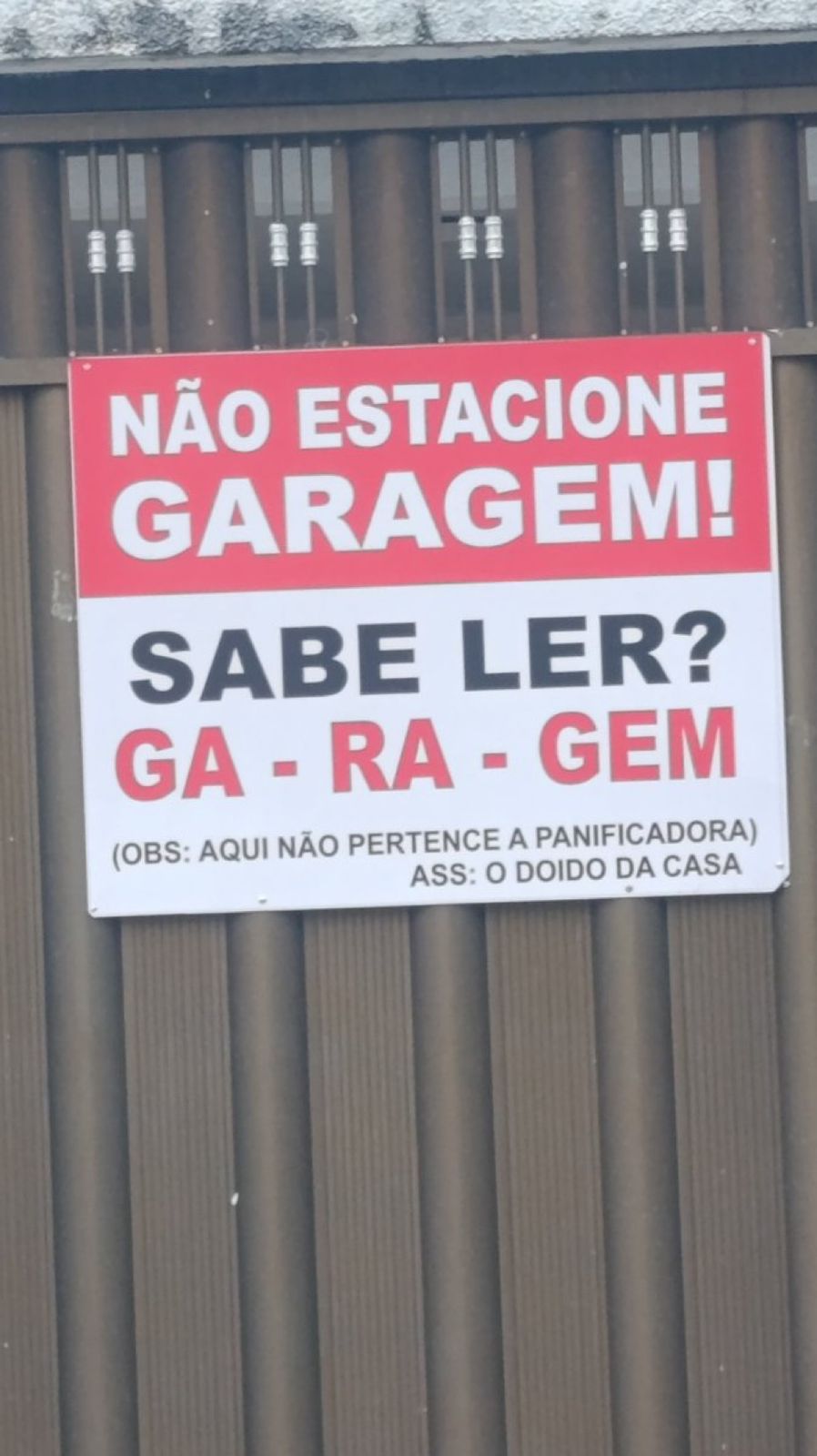 Placa na porta de garagem chama atenção de quem passa pela rua: “sabe ler?”