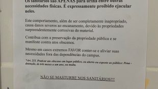 Placa colocada em banheiro masculino de faculdade chama atenção para comportamento inapropriado