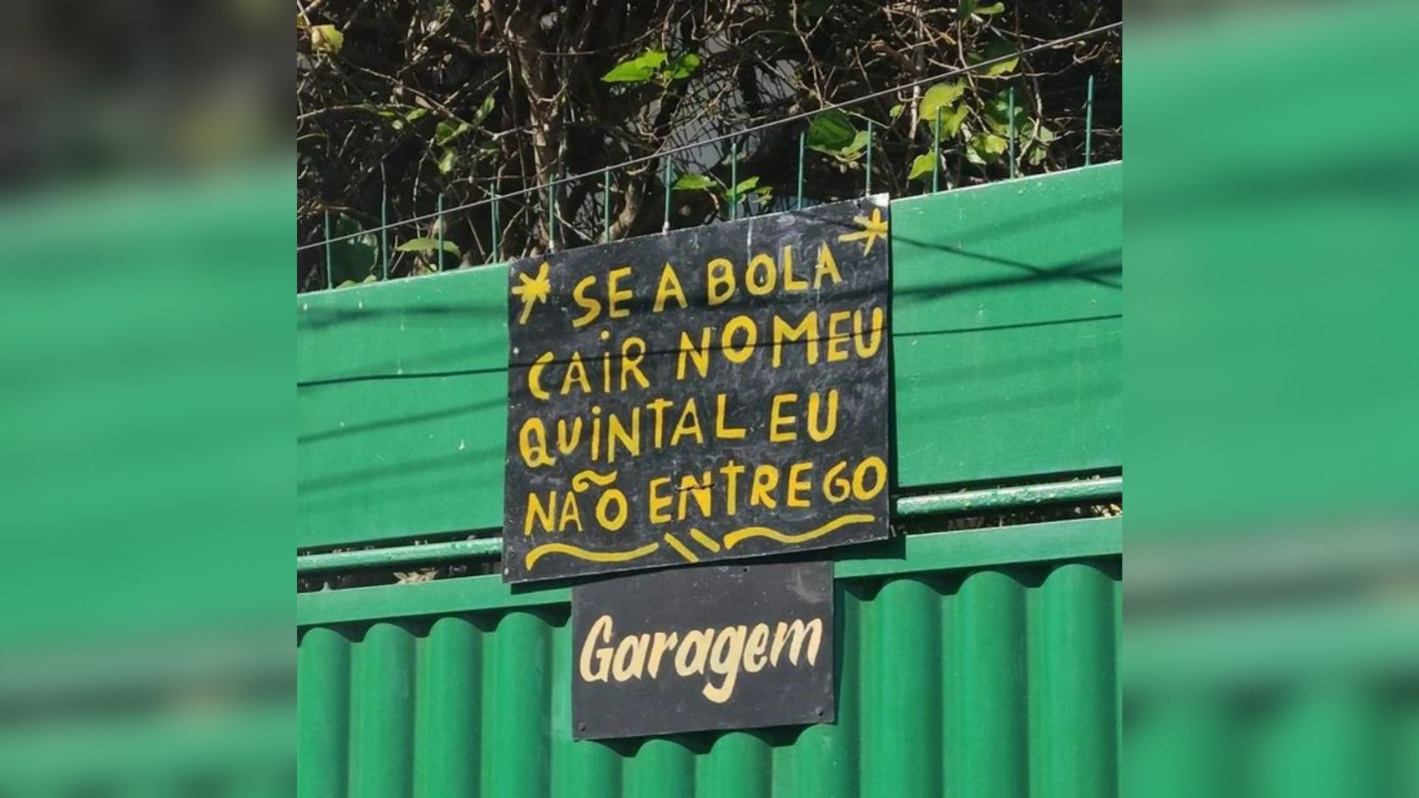 Placa chama atenção de quem passa na porta de residência com portão verde