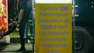 Placa com "promoção" chama a atenção de quem passa na porta de hamburgueria