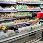 Trabalhador repondo produtos em supermercado