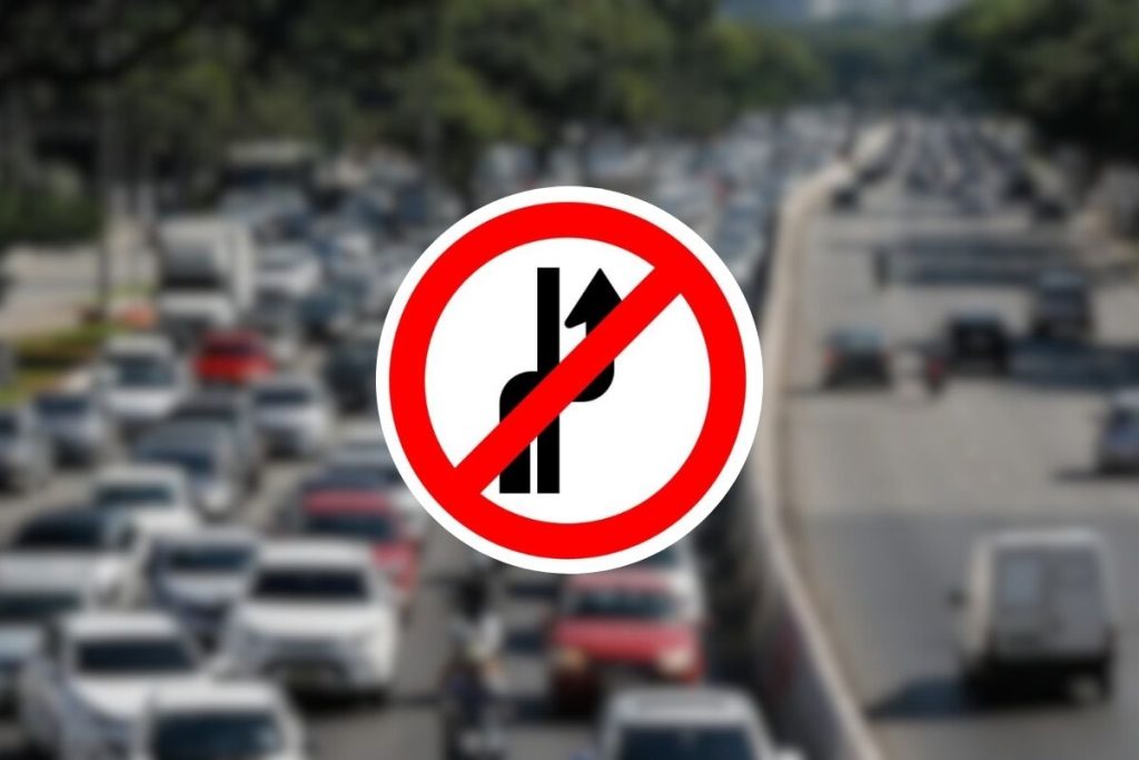 Placa de trânsito com seta curva e faixa vermelha: o que ela realmente quer dizer?