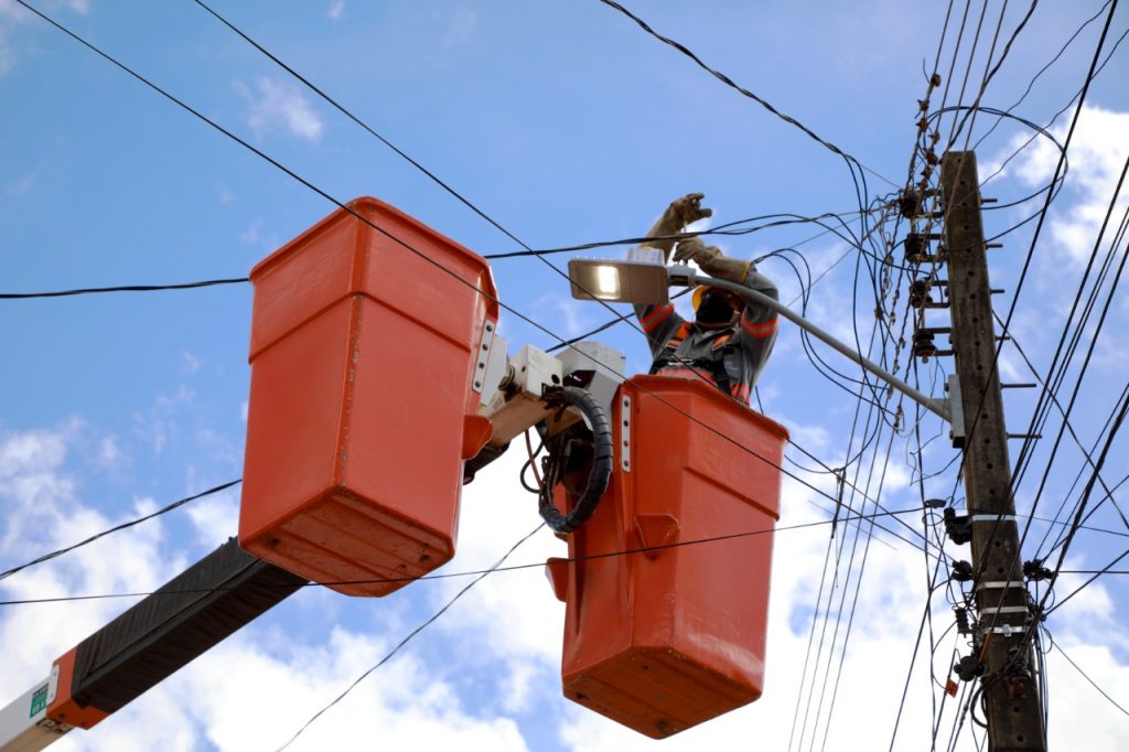 Trabalhador realiza troca de lâmpadas, iluminação pública.