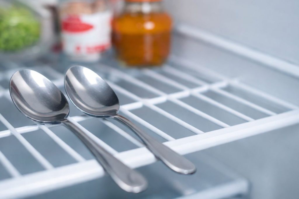 Colocar duas colheres de metal na geladeira: