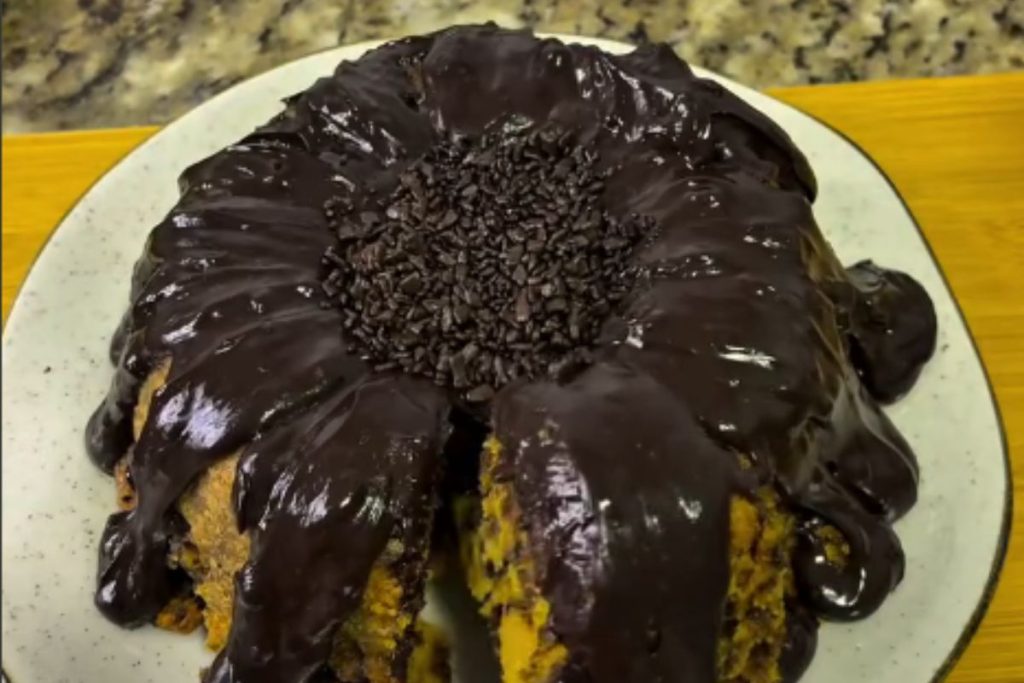 Aprenda a fazer bolo de cenoura formigueiro com granulado na massa e decoração de chocolate em formato de flor.