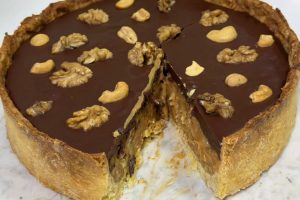 Receita de torta de Páscoa crocante com doce de leite, nozes e ganache de chocolate com laranja. Veja o passo a passo completo.