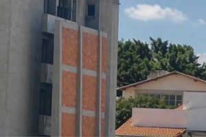 Vingança servida fria: homem ergue muro de 14 metros após prédio vizinho expor sua intimidade