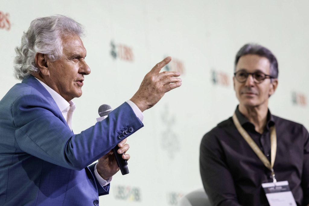 Ronaldo Caiado fala ao microfone durante evento, enquanto Gilberto Kassab acompanha a apresentação. Os dois são citados em articulações políticas envolvendo uma possível chapa para as eleições presidenciais de 2026