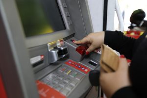 Pessoa sacando salário no caixa