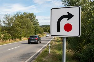 Entenda o que significa a placa de trânsito com seta para a direita e ponto vermelho sobre fundo branco e quando ela deve ser seguida. (Foto: Portal 6)