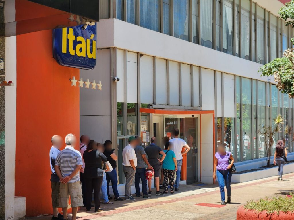 Pessoas aguardam atendimento em frente a uma agência do Itaú