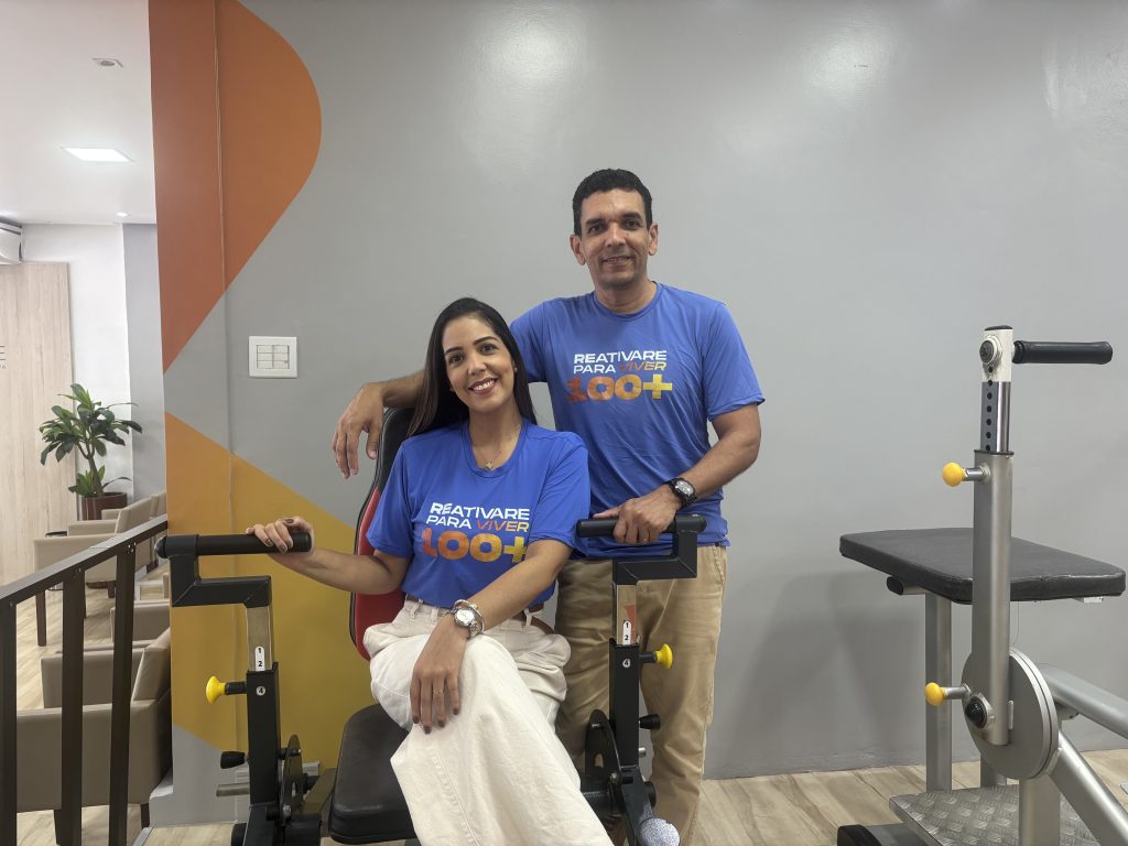 Casal em uma academia terapêutica acompanhando idosos durante exercícios físicos