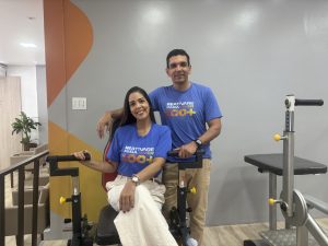 Casal em uma academia terapêutica acompanhando idosos durante exercícios físicos