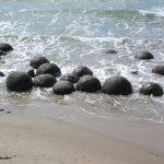 Esferas gigantes de pedra espalhadas pela areia da Koekohe Beach, na Nova Zelândia, representando as formações Moeraki Boulders