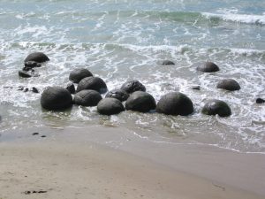 Esferas gigantes de pedra espalhadas pela areia da Koekohe Beach, na Nova Zelândia, representando as formações Moeraki Boulders