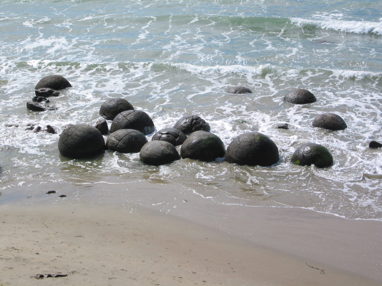 Esferas gigantes de pedra espalhadas pela areia da Koekohe Beach, na Nova Zelândia, representando as formações Moeraki Boulders