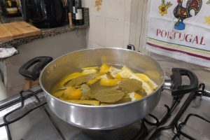 Panela com cascas de limão e folhas de louro fervendo no fogão, representando truque caseiro para perfumar a casa