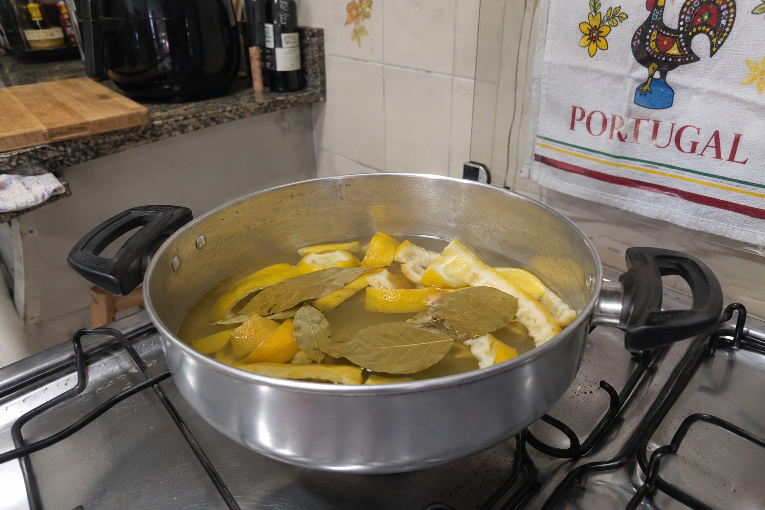Panela com cascas de limão e folhas de louro fervendo no fogão, representando truque caseiro para perfumar a casa