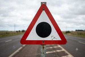 O que significa a placa de trânsito triangular com a borda vermelha e um círculo no centro, segundo o Departamento de Trânsito