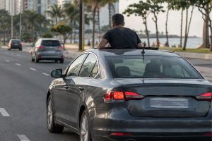 Passageiro fica em pé no banco do carro e coloca o corpo para fora do teto solar com o veículo em movimento, carro é parado pela polícia e motorista descobre que será multado e levará pontos na CNH