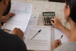 Pessoas calculando o valor da parcela para comprar uma casa de dois quartos