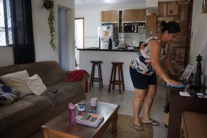 Sala de casa com objetos espalhados sobre móveis antes da organização