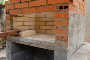 Churrasqueira em construção com tijolos refratários, tijolos comuns e blocos de concreto