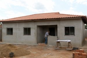 Casa térrea simples de três quartos em construção com pedreiro trabalhando