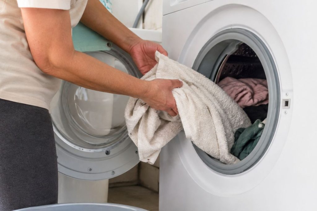 toalha sendo colocado na máquina