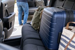 Malas e sacolas acomodadas sobre o banco traseiro de um automóvel antes de uma viagem