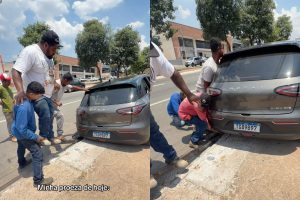 Cerca de 12 pessoas se mobilizaram para retirar o carro que ficou preso em um bueiro na Avenida T-63, em Goiânia. (Foto: Reprodução/Redes sociais/Leonora Cristina)