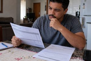 Trabalhador compara atestado médico com contracheque após identificar desconto no pagamento