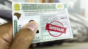 pessoa segurando CNH suspensa