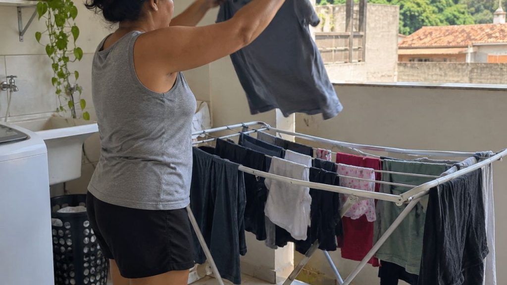 Pessoa estende roupas espaçadas em um varal para favorecer a circulação de ar e reduzir os amassados