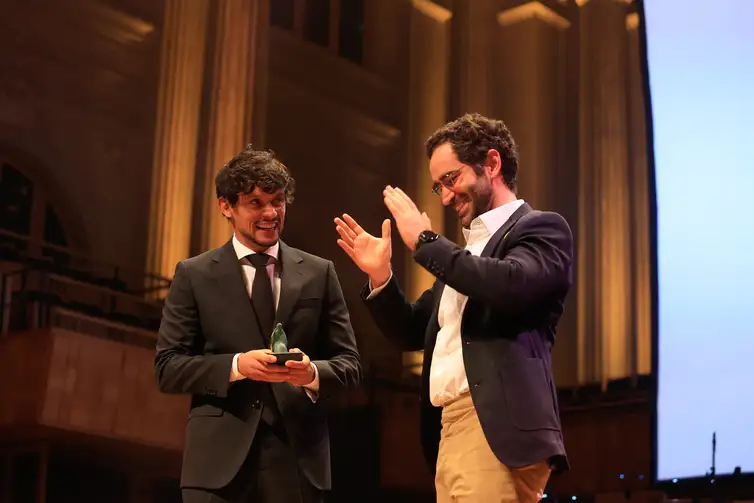 Influenciador literário Pedro Pacífico (d), conhecido pelo perfil Bookster, recebe o prêmio do jogador Gustavo Scarpa.